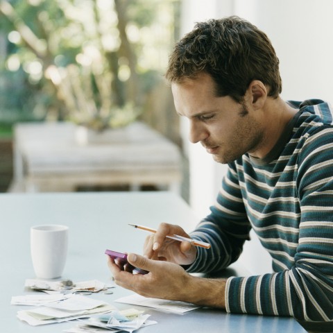 A guy using his phone to calculate something.