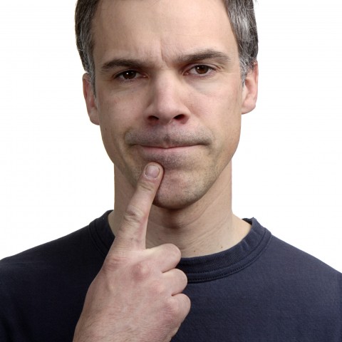 A Man Holding a Finger to His Chin while Thinking Deeply