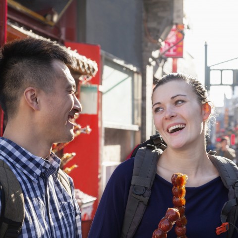 A Man and Woman Having a Conversation while Eating Street Food