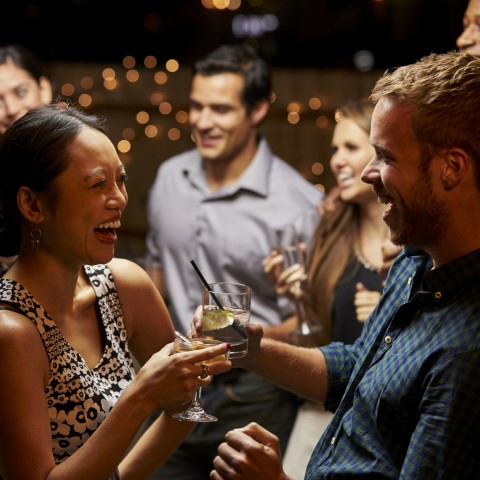 Two People Chatting and Laughing at a Party with Drinks