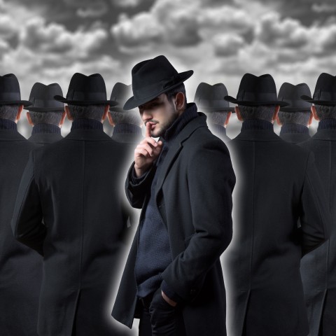 Men in Black Coats and Hats Walking Under Gray Sky