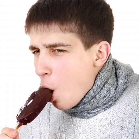 A Guy Getting a Brain Freeze while Eating a Chocolate Popsicle