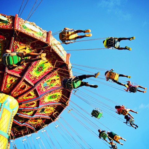 View from below of a carnival swing, with riders directly above the viewer