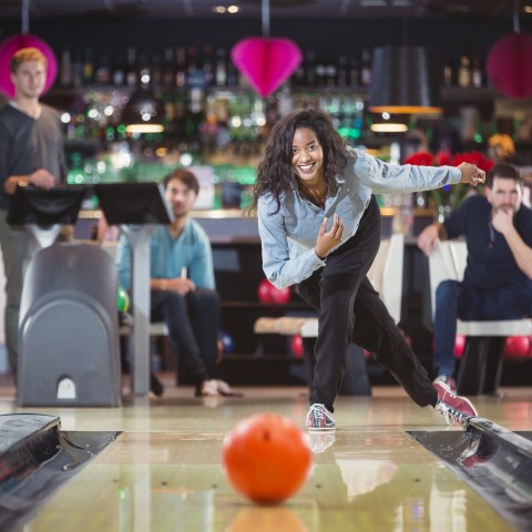 A Woman Throwing a Bowling Ball