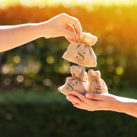 A Person Collecting Money with Both Hands and Another Delivering It to Him