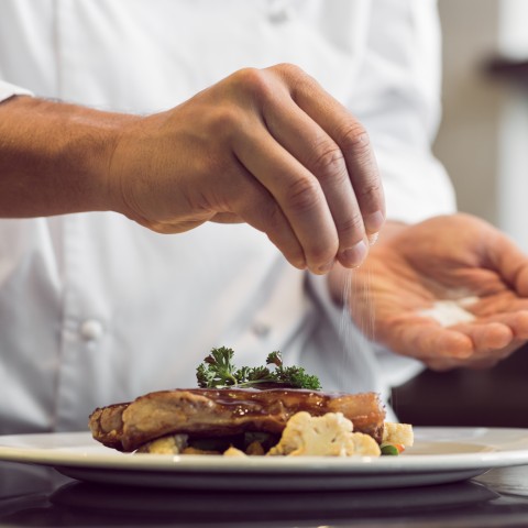 A Chef Seasoning a Steak