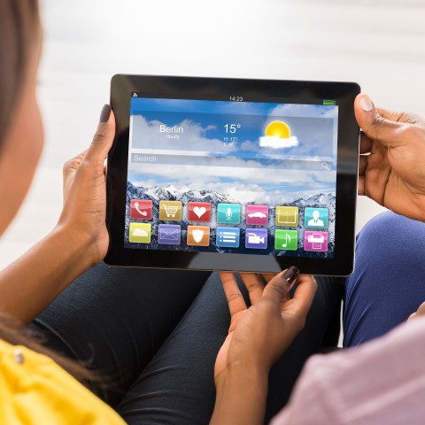 A Woman Checking the Weather on a Tablet