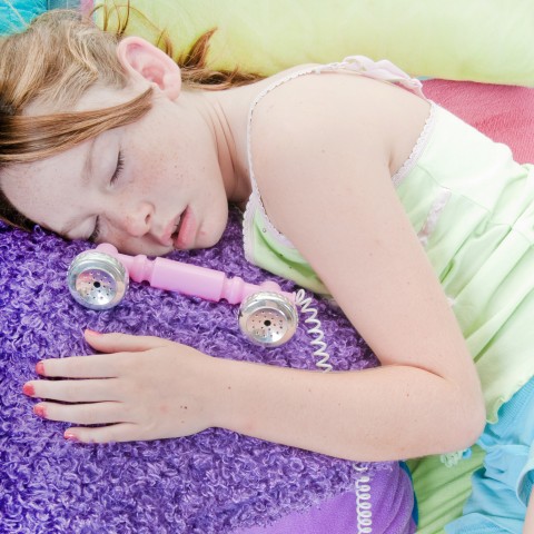 A Little Girl Sound Asleep beside a Toy Telephone