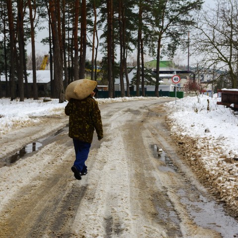 Man Carrying Sack in Snowy Conditions