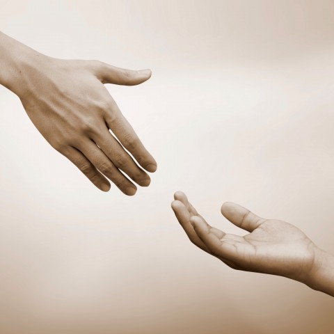 One Hand Extending Toward Another to Help