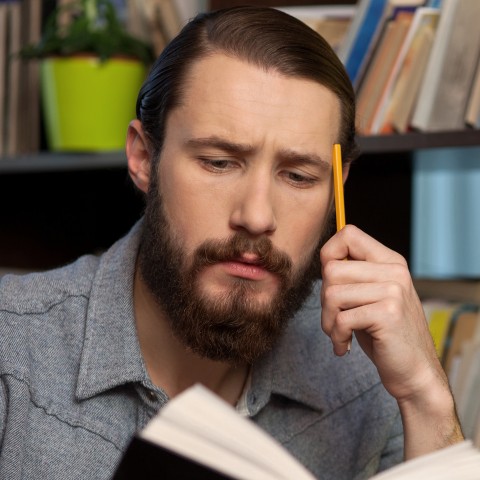 Man Sitting and Writing at Desk