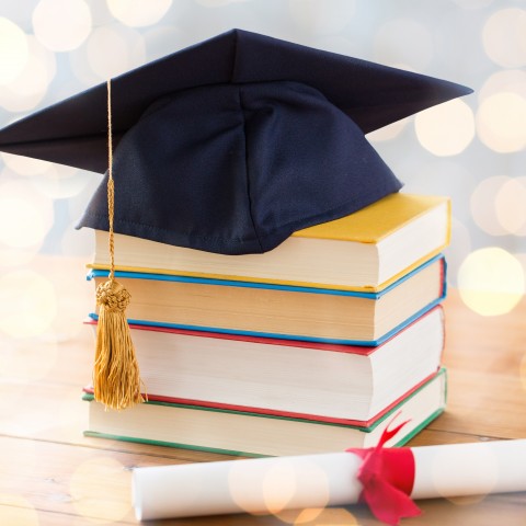 Graduation cap, degree, and books