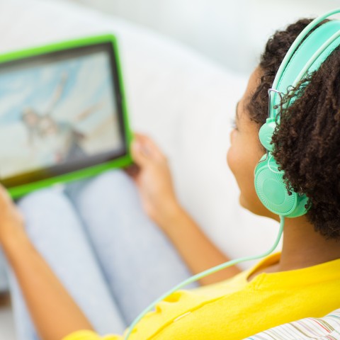 A young girl watching a movie on her iPad