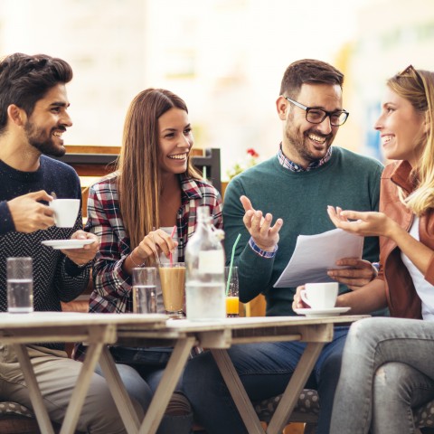 A Group of Four Friends Having Coffee Beverages Together and Chatting