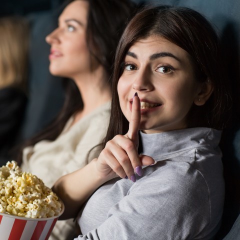 A Woman Shushing Someone in a Movie Theater