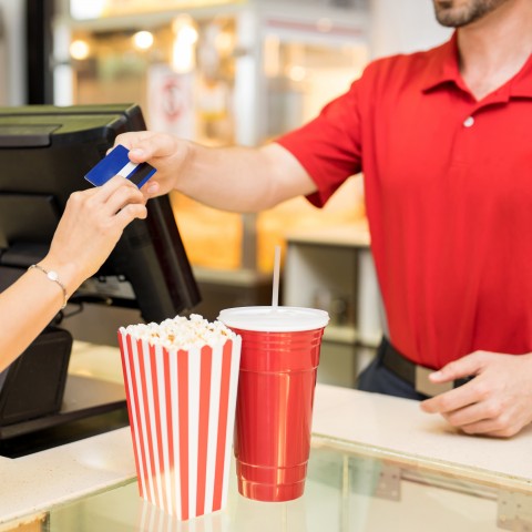 Someone Purchasing Popcorn and a Drink at a Movie Theater