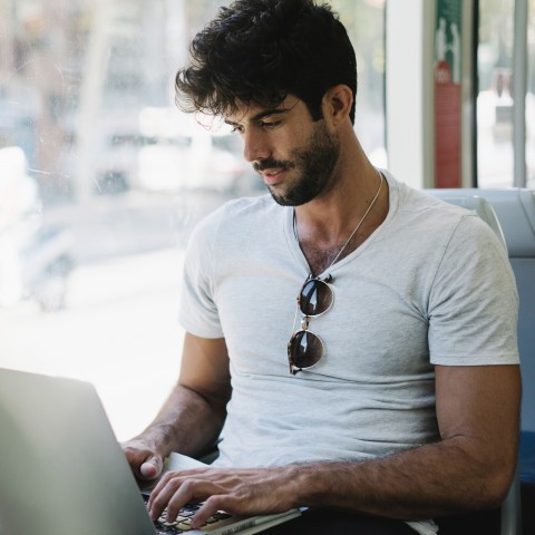 A Young Man Using His Laptop in Public