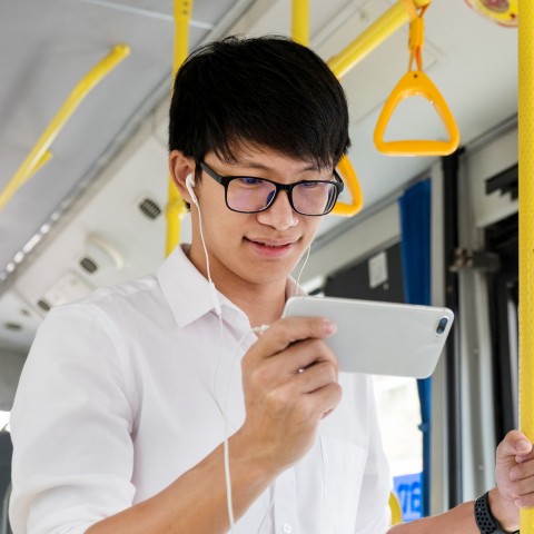 Person viewing phone on a metro