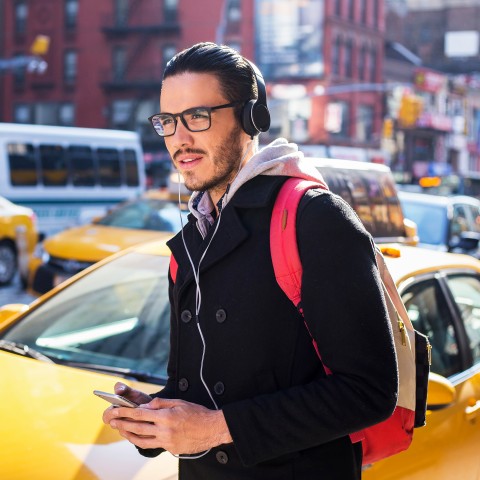 A man walking in the city with a headset on