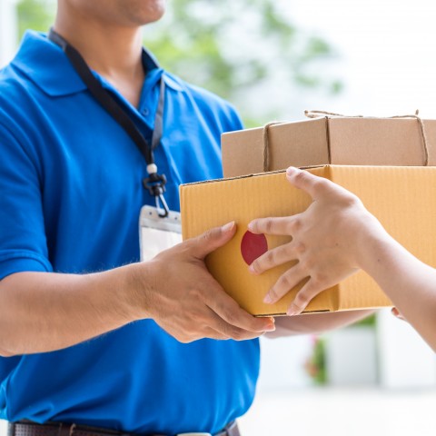 Delivery worker handing a package to a customer