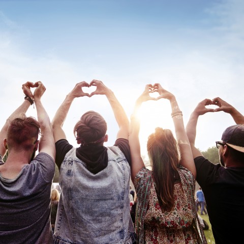 Four People Making a Heart Sign with Their Hands in the Air