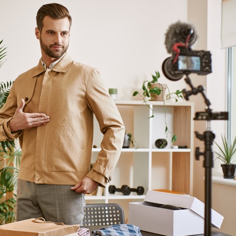 Man showing off a jacket in front of a camera