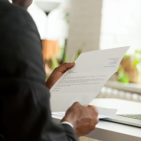 A Man Reading a Business Letter/Official Correspondence in an Office