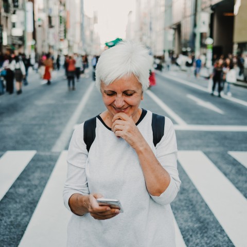 An Old Woman Looking Down at Her Phone and Smiling