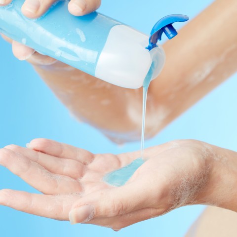 A woman putting soap in her hand while washing herself