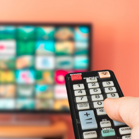 Someone pointing a remote at a TV