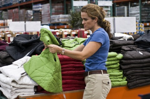 A Woman Looking at Different Vests in a Store