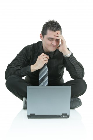 A Desperate Man Looking at His Laptop in Anger