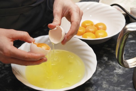 Hands Breaking Open an Egg into a Bowl
