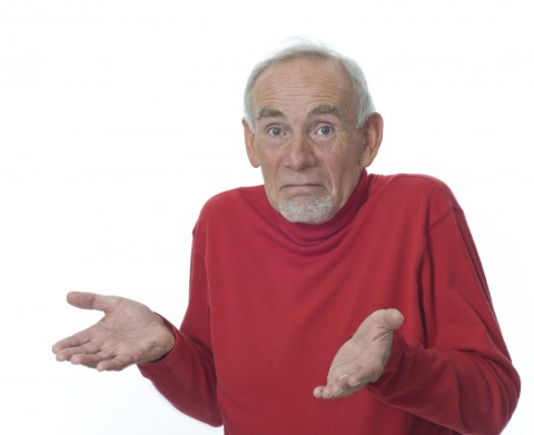 An Old Man in a Red Shirt Shrugging His Shoulders with His Palms Up