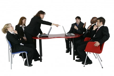 Six People Around a Red Table at a Meeting