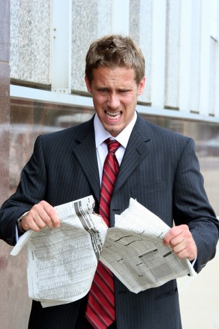 Man Ripping Up Newspaper in Anger