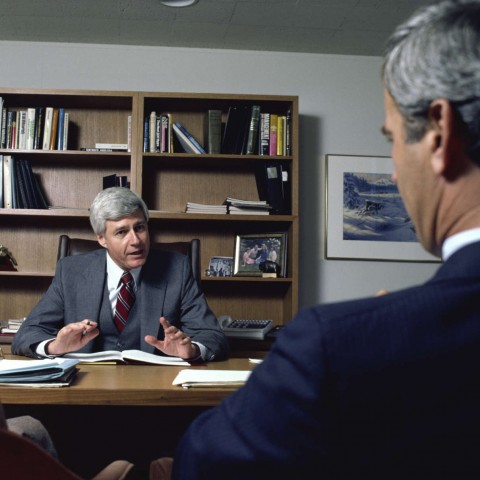 Mature Officials Busy in a Conversation at a Workplace