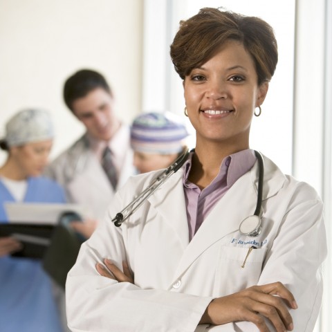 A Confident, Friendly Female Doctor Dressed in a White Medical Gown.