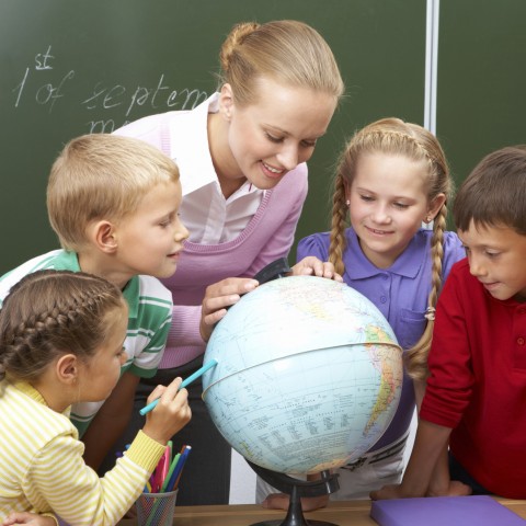 Teacher and Children Looking at a Globe in the Classroom