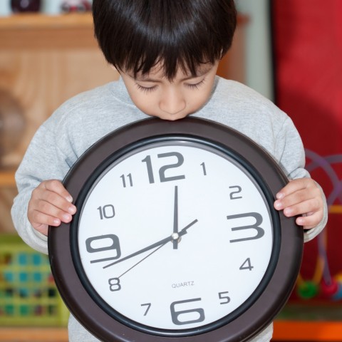 a child holding a clock