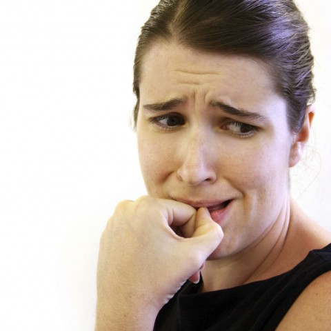 A Nervous Woman Biting Her Thumb Nail