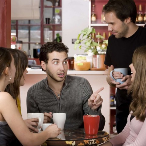 Three Friends Chatting and Laughing while Having Coffee Drinks