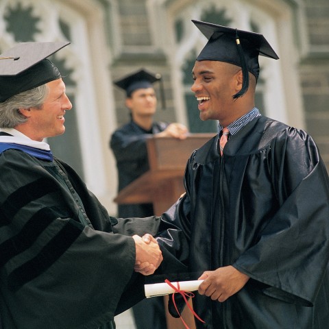 A Man Shaking Hands with a Teacher as He Receives His Diploma