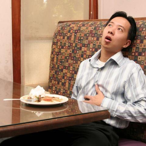 A Man Having Digestion Troubles After Eating a Huge Meal