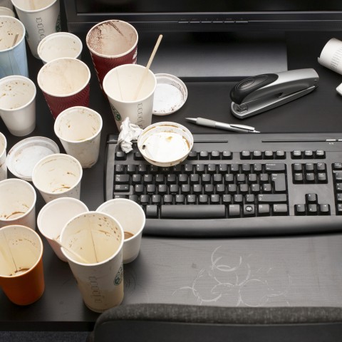 Desk Covered in Empty Coffee Cups