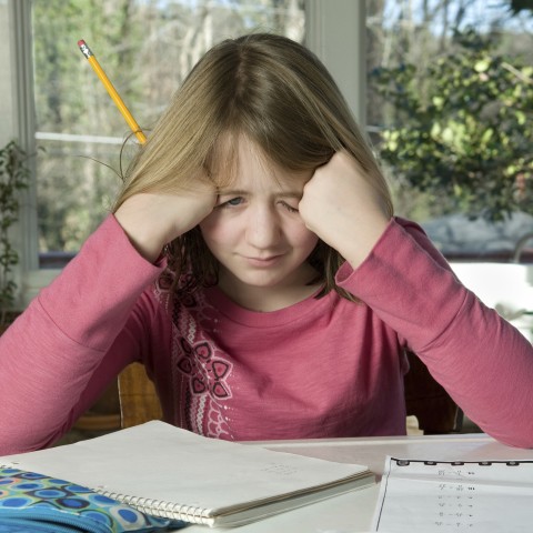 A Frustrated Girl in the Classroom Holding Her Head with Her Hands